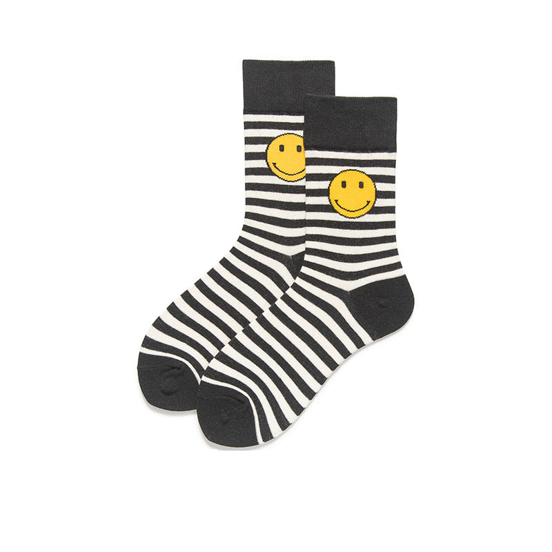 This pair of socks features a white base with black stripes and a big smiley face on the ankle.