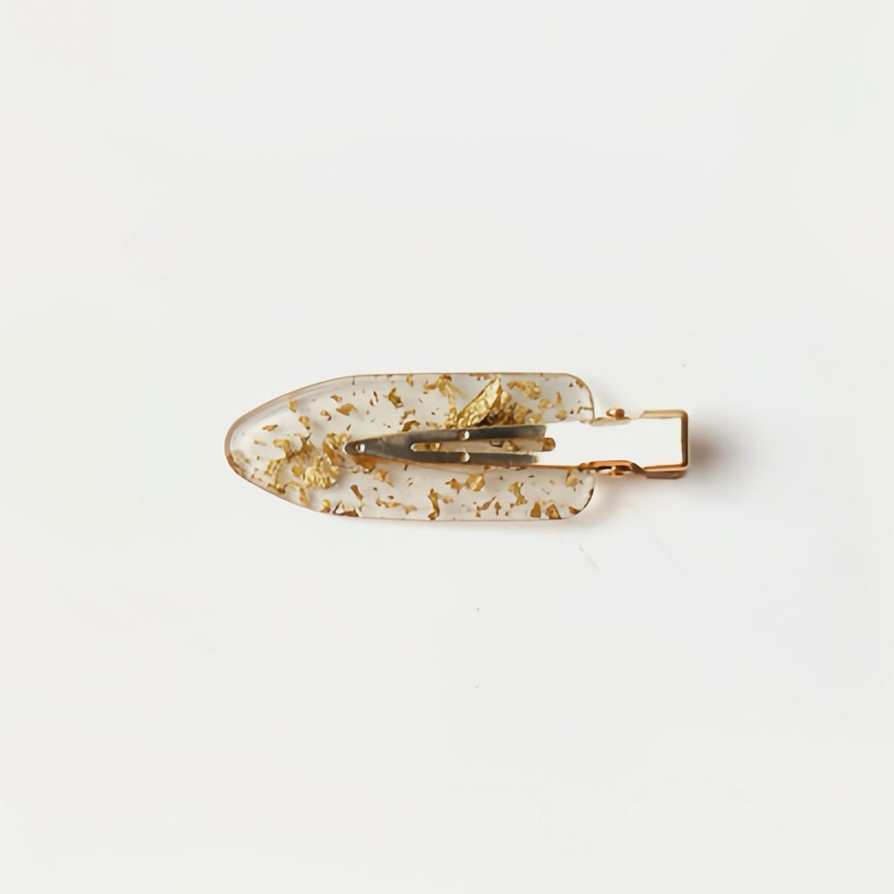 A close-up of the Transparent Resin with Gold Flakes no-crease hair clip, highlighting its luxurious and shimmering design. This 6 cm clip is perfect for adding an elegant touch to your hairstyle while ensuring a smooth, crease-free hold.