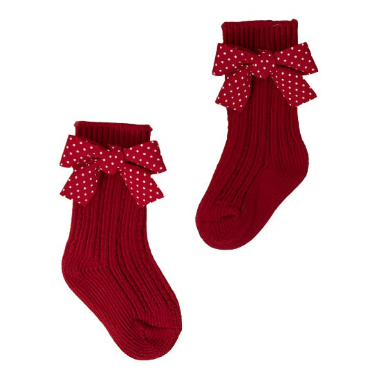 Beautiful red socks with small polka dot bows, perfect for adding a touch of charm to a kid's outfit during the holidays.