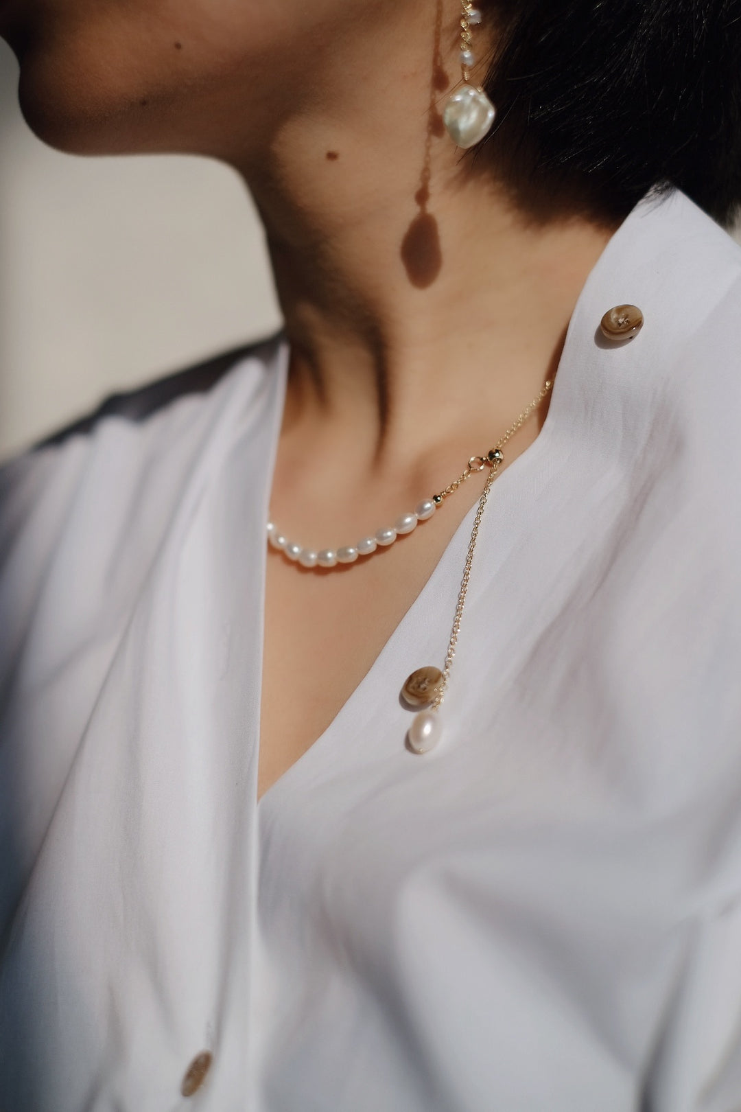 The clean white shirt complements the necklace’s understated luxury.