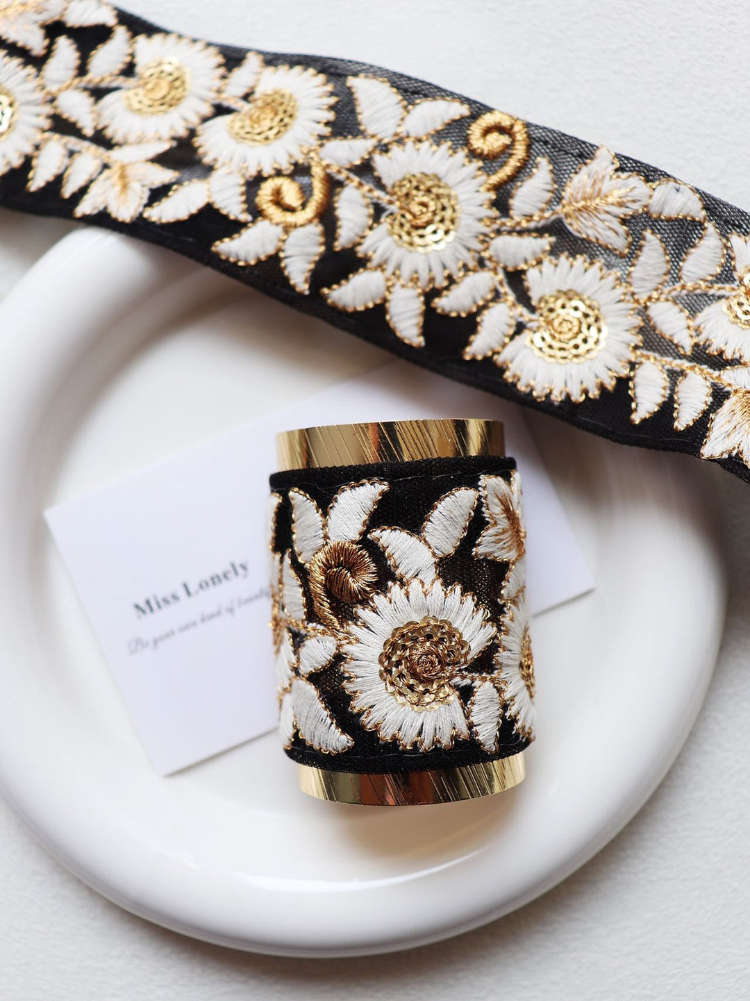 Featuring a black base with white and gold daisy-like flowers, this hair wrap is a beautiful contrast of colors. The delicate daisies bring a charming and timeless appeal, perfect for any occasion.