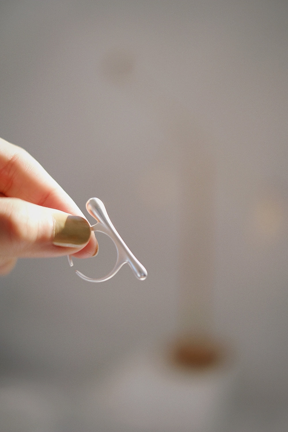 The Bone sterling silver ring held delicately between two fingers, emphasizing its eye-catching design and refined craftsmanship. The ring’s innovative shape makes it an ideal choice for both casual and formal occasions.