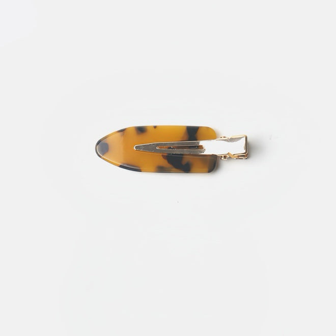 Featured here is the Tortoiseshell Dark no-crease hair clip, with its deep and bold design. Measuring 6 cm, this clip is perfect for making a statement while keeping your hair smooth and dent-free, ideal for any occasion.