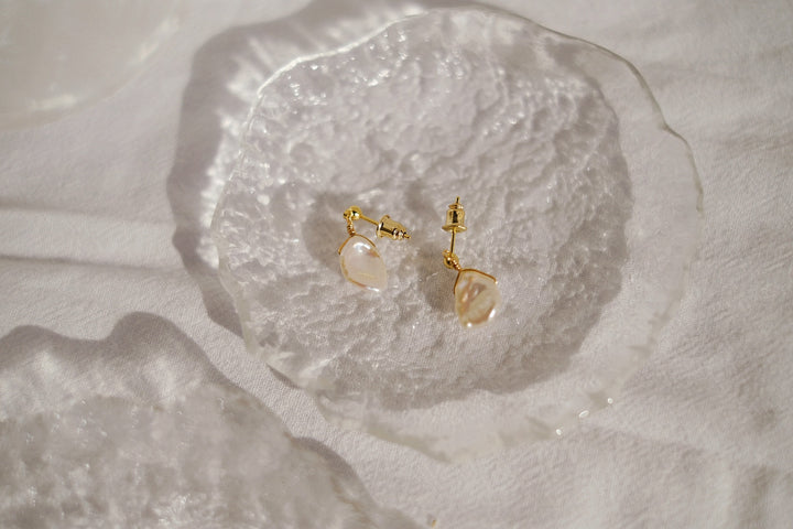 A side perspective showing the coin pearls' flat profile and the secure 14k gold-filled sterling silver posts, emphasizing their minimalist yet sophisticated style