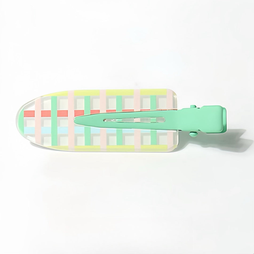 This Transparent Checkered Resin Hair Clip is adorned with a colorful checkered pattern in light pink, bright pink, bright green, and sky blue. The bright green handle matches the vibrant green line in the pattern, making this 6 cm clip a fun and eye-catching accessory.