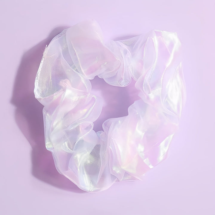 A close-up of this opalescent scrunchie, showcasing its 9 cm diameter and translucent material with a soft, iridescent glow. This elegant scrunchie captures the light beautifully, making it a perfect accessory for any occasion.