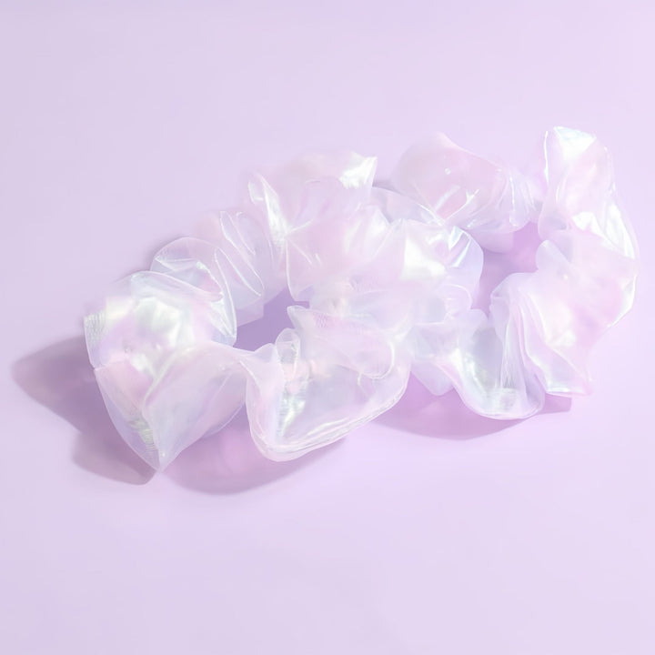 The Translucent Pearl Shine Hair Scrunchie is displayed in its classic 9 cm circular form, highlighting the delicate and airy fabric that gives it a unique, shimmering effect. Its ethereal sheen is especially complimentary to blonde hair, adding a touch of light-catching elegance to any look.