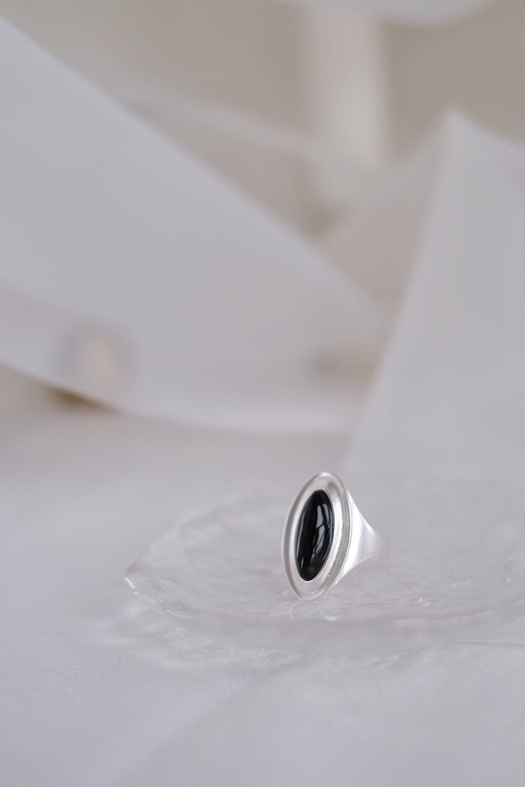 A close-up shot of the Goddess Silver Open Ring with the black onyx gemstone, highlighting the deep, rich color of the gemstone against the matte silver band.