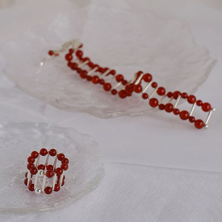 An elegant display featuring both the red onyx bracelet and ring together, showcasing their harmonious design and exquisite craftsmanship.