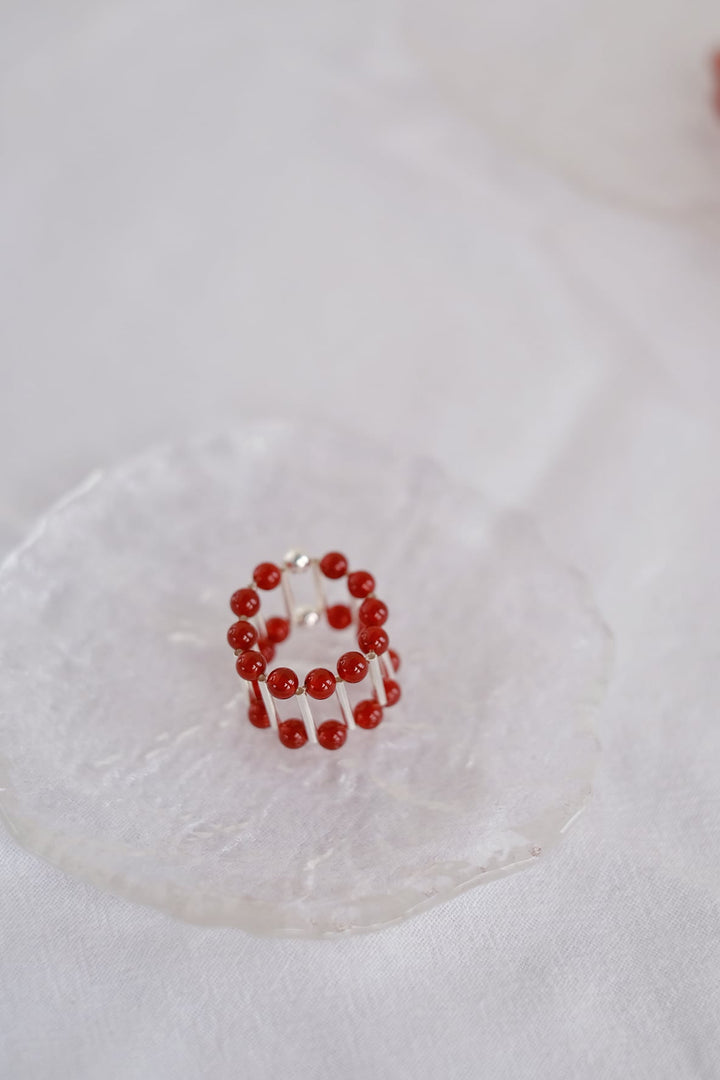 A detailed shot of the red onyx ring, highlighting its sleek design and subtle elasticity for a comfortable fit.