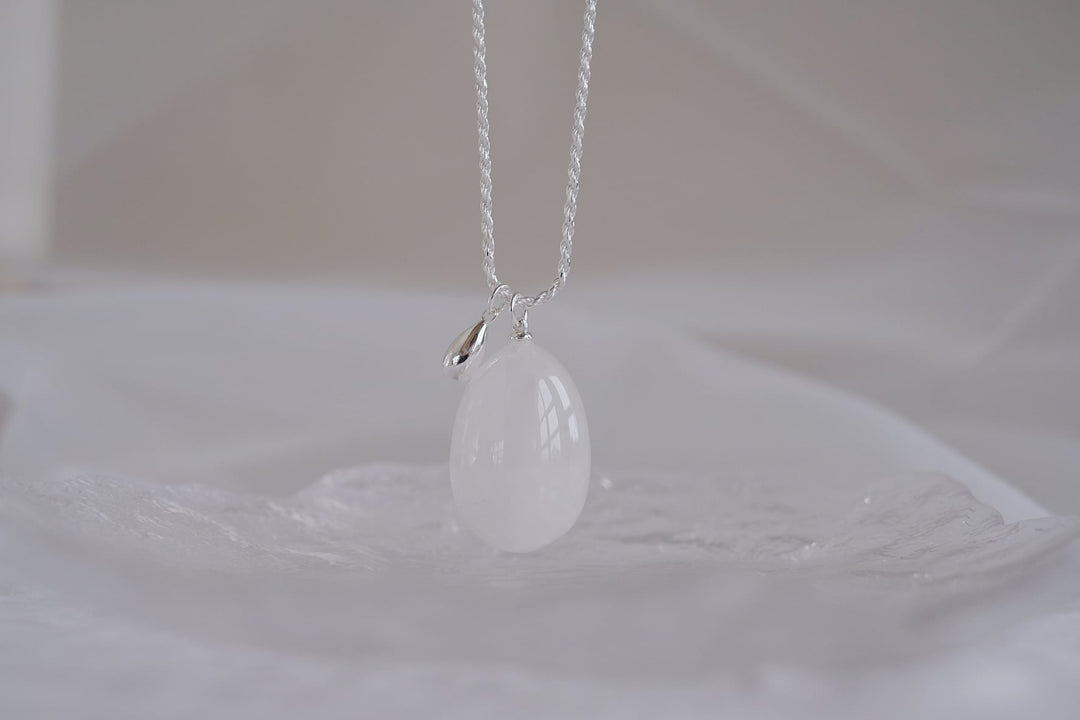 Close-up of the Teardrop necklace with a large white crystal pendant.