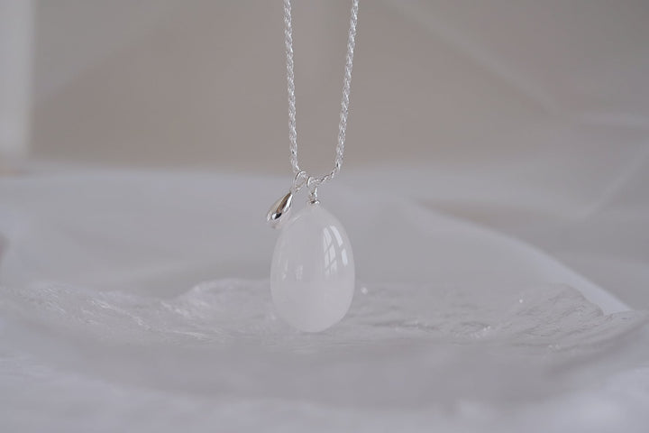 Close-up of the Teardrop necklace with a large white crystal pendant.