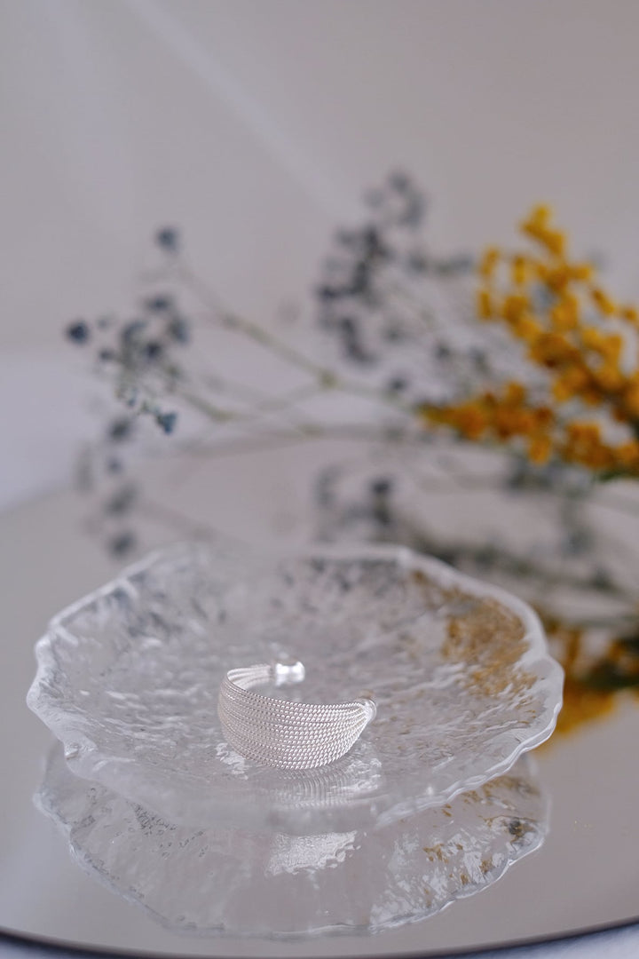 Detailed shot of the textured silver strands on the Silver Ripples ring, reflecting light beautifully.