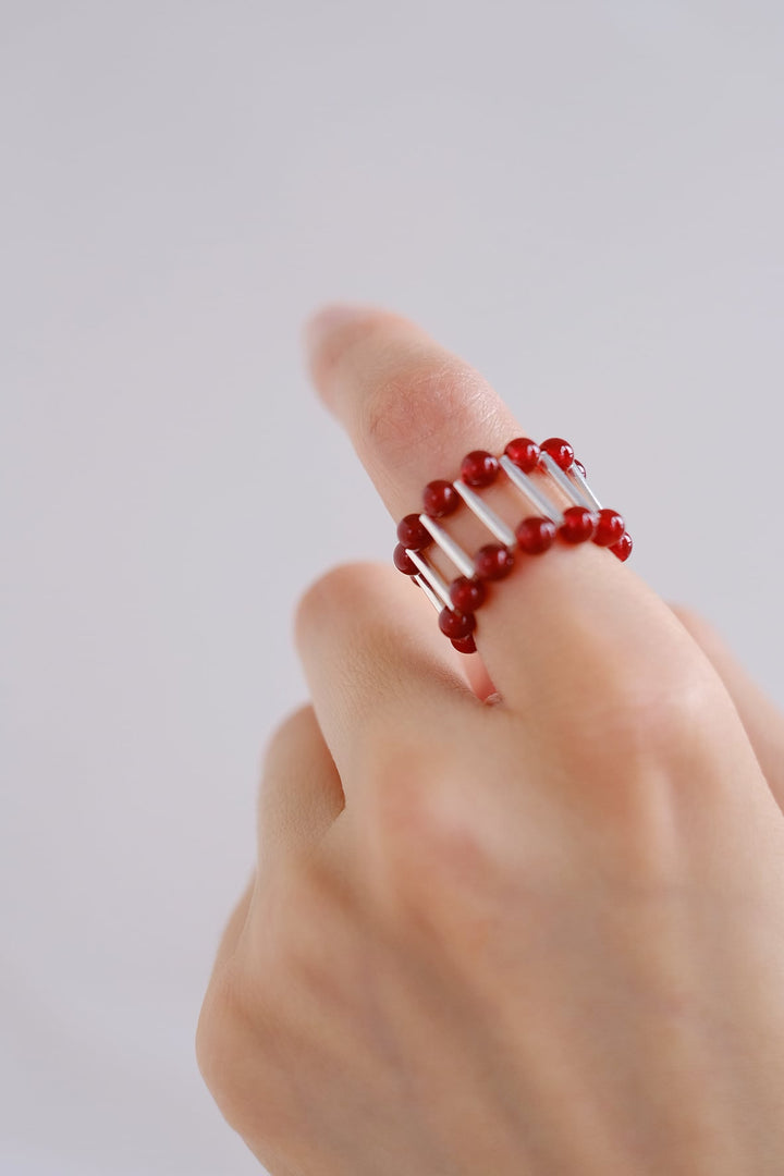 A close-up of the red onyx ring worn on a finger, offering a glimpse of its elegant design and comfortable fit.