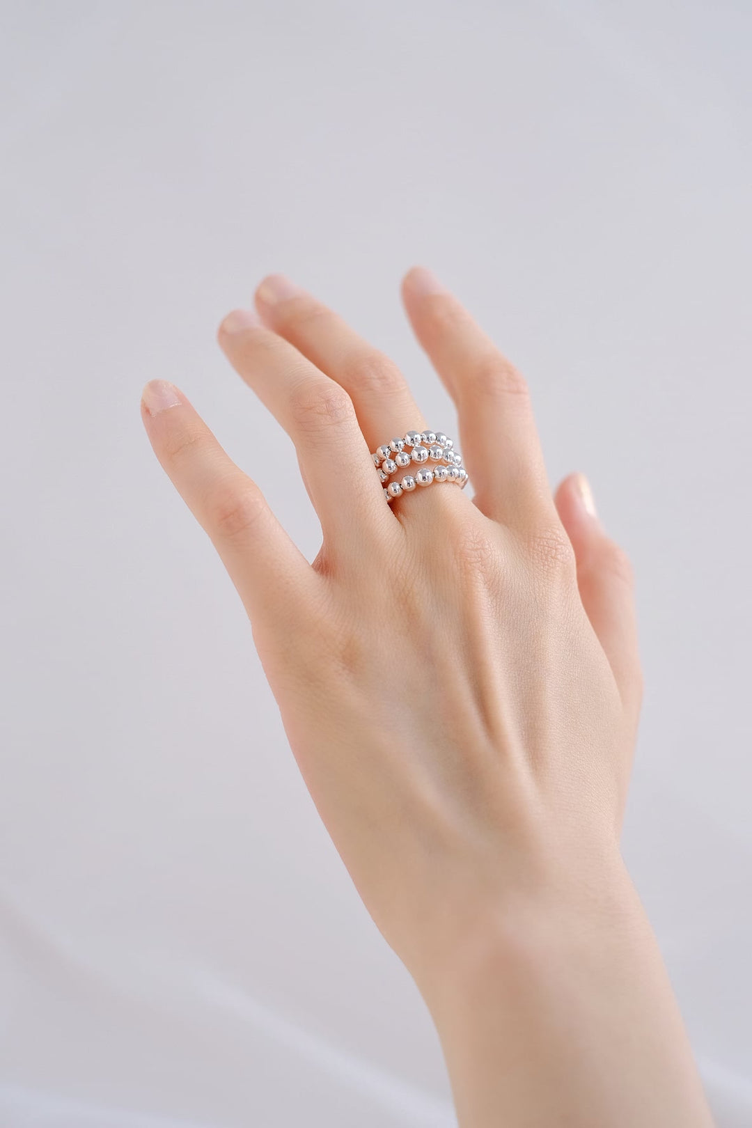 The ring’s chunky design adds a touch of modern elegance to the hand, making a bold statement.