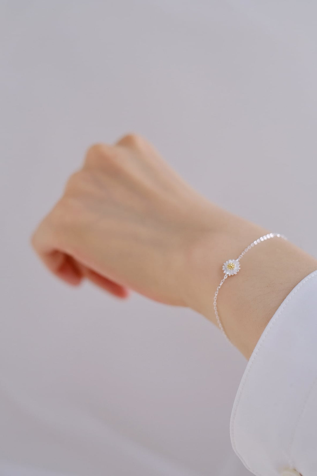 A close-up of the summery Daisy bracelet. The delicate details of the bracelet adds a touch of femininity to the wrist.