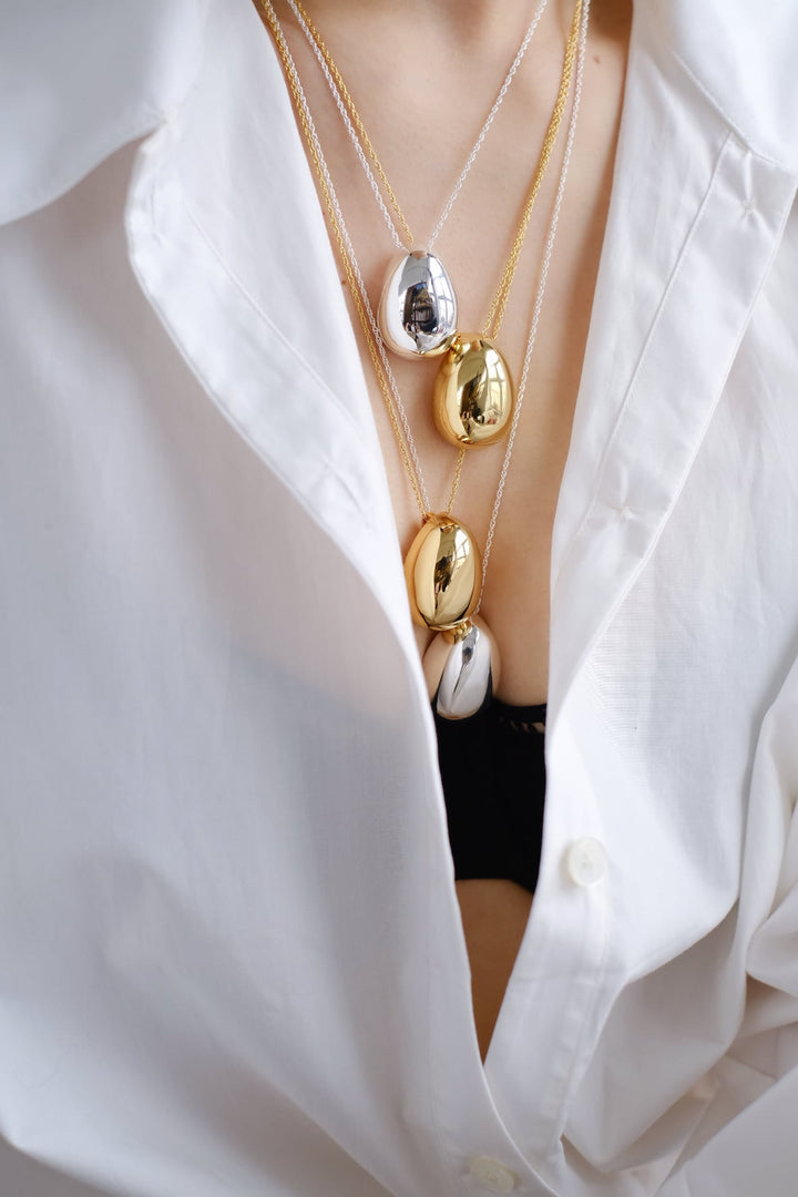 Gold and silver necklaces styled together for a layered look.