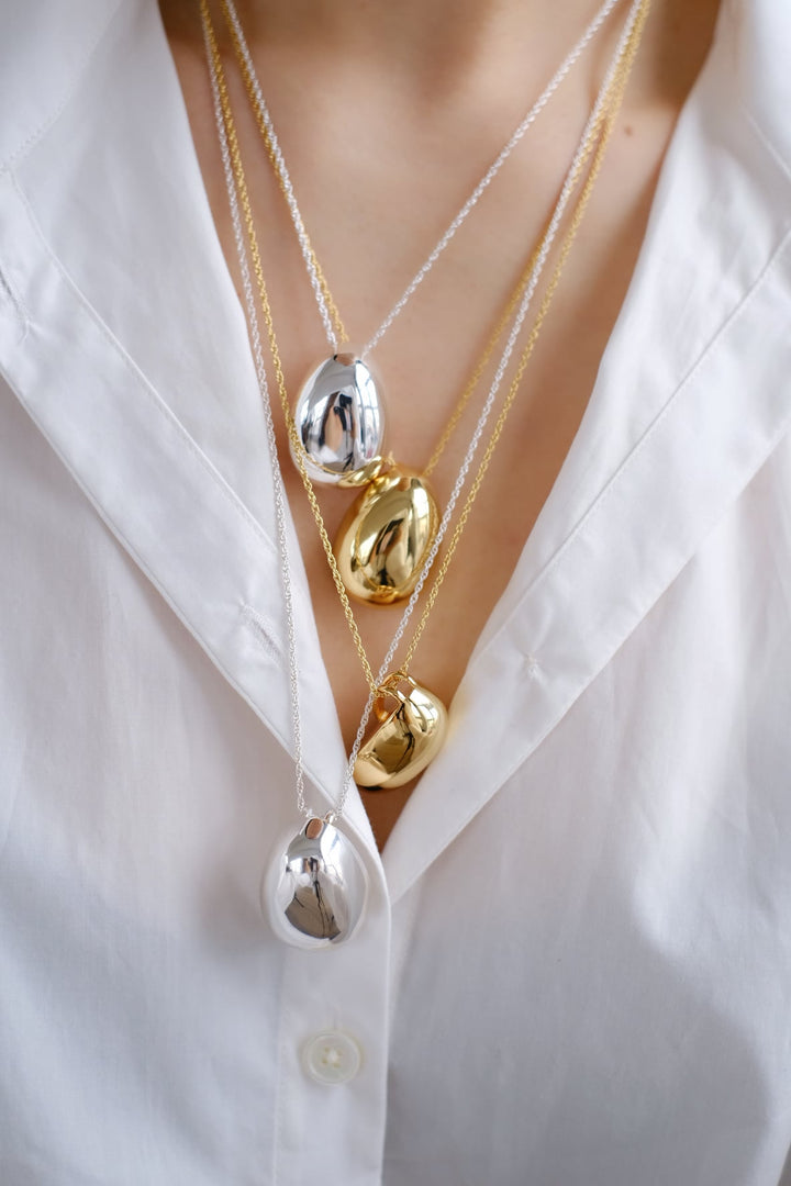 Four Athena necklaces worn together, showcasing gold and silver combinations and the various length options.