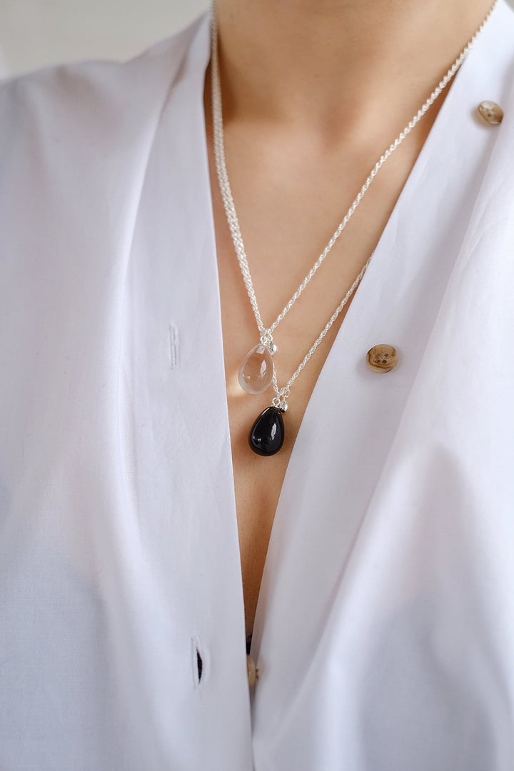 Layered look featuring the small Teardrop necklaces with white crystal and black obsidian pendants, worn together to demonstrate their contrasting colors and sparkling elegance.