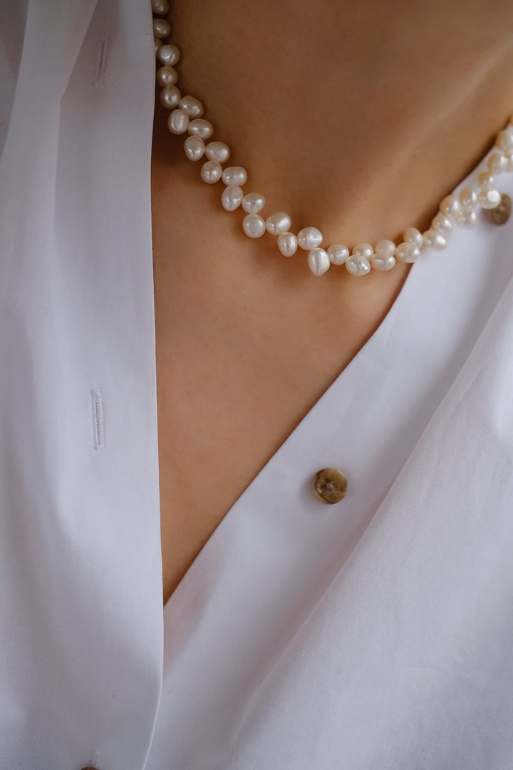 This unique pearl necklace effortlessly elevates any outfit with its youthful charm and sophistication.