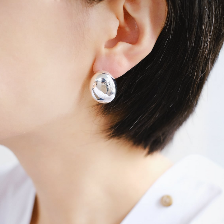 A side profile of a model wearing the Ovals stud earrings, demonstrating their perfect fit and elegant appearance.