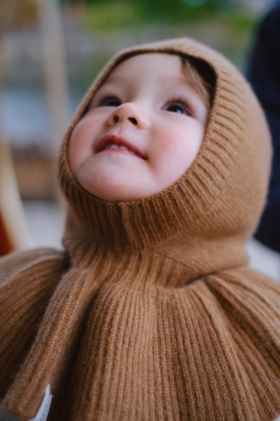 Close-up of a caramel hat, highlighting the texture and gentle curves as it wraps around the child’s head.