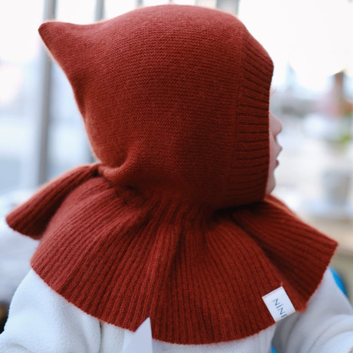 Side view of the Autumn Red hat on a young child, emphasizing the bold hue and soft texture. The rich, deep red tones bring a warm, autumnal vibe to the image.