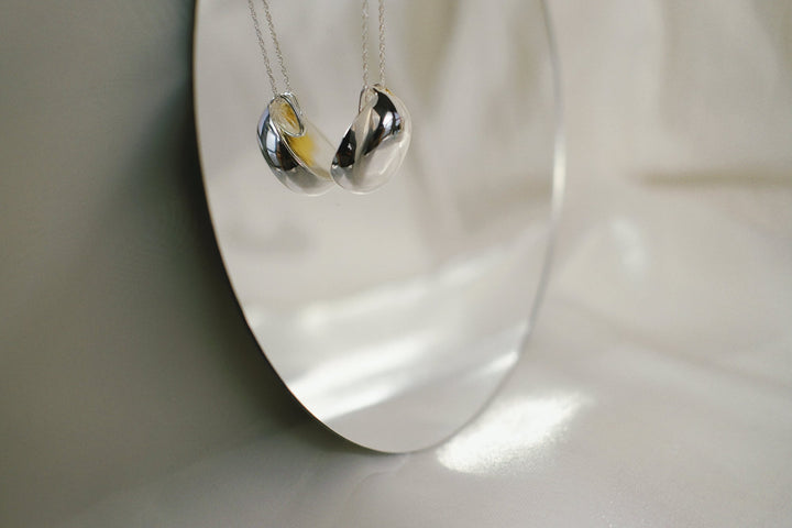 Detail shot of the oval pendant on the silver necklace.