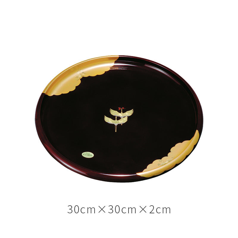 The "Golden Clouds and Cranes" tray is finished in a rich, dark black lacquer, which beautifully contrasts with the intricate gold leaf decoration. A pair of cranes is captured in a serene moment above shimmering golden clouds.