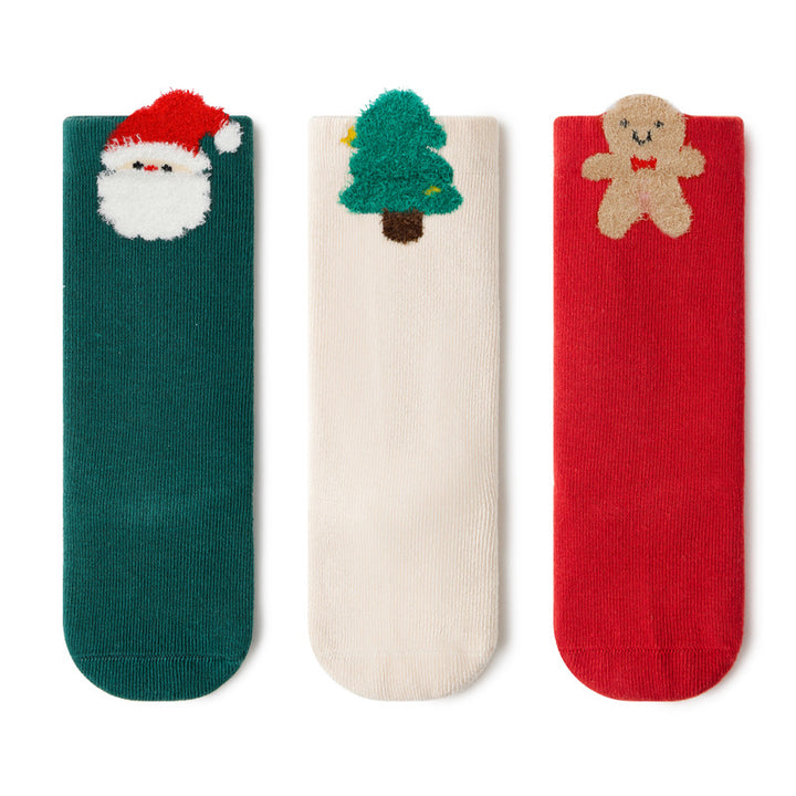 A display of all three pairs of socks—green with Santa, white with a Christmas tree, and red with a gingerbread man—highlighting the festive designs.