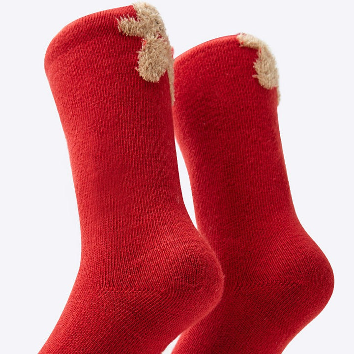 A close-up view of the red socks featuring the gingerbread man, emphasizing the detailed and playful pattern.