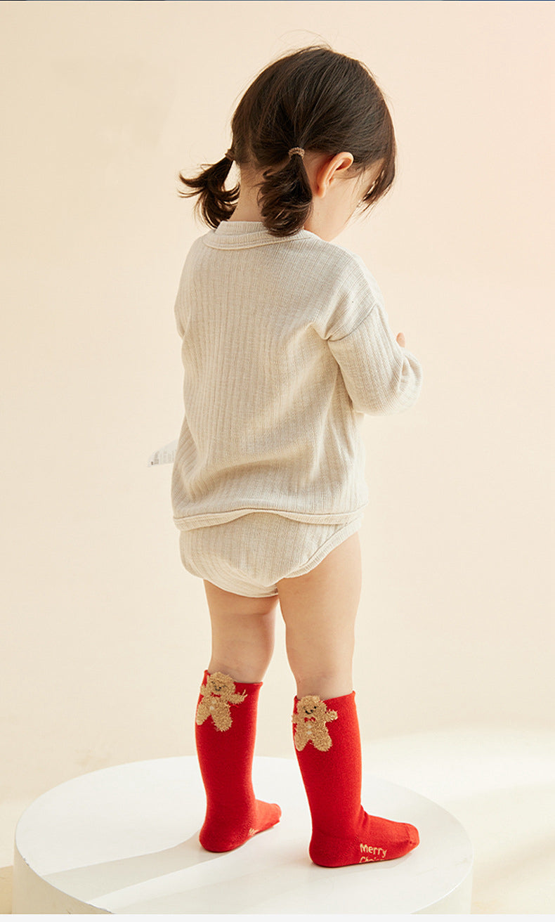 A toddler wearing the red socks with a gingerbread man, showcasing the cute design and perfect fit.