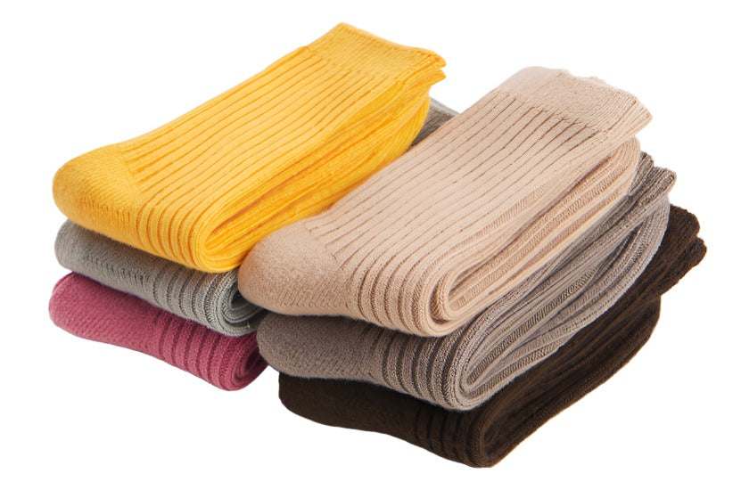 A vibrant assortment of children's wool blend socks in various colors, including berry pink, sunny yellow, oat beige, light gray, dark brown, and stone gray.