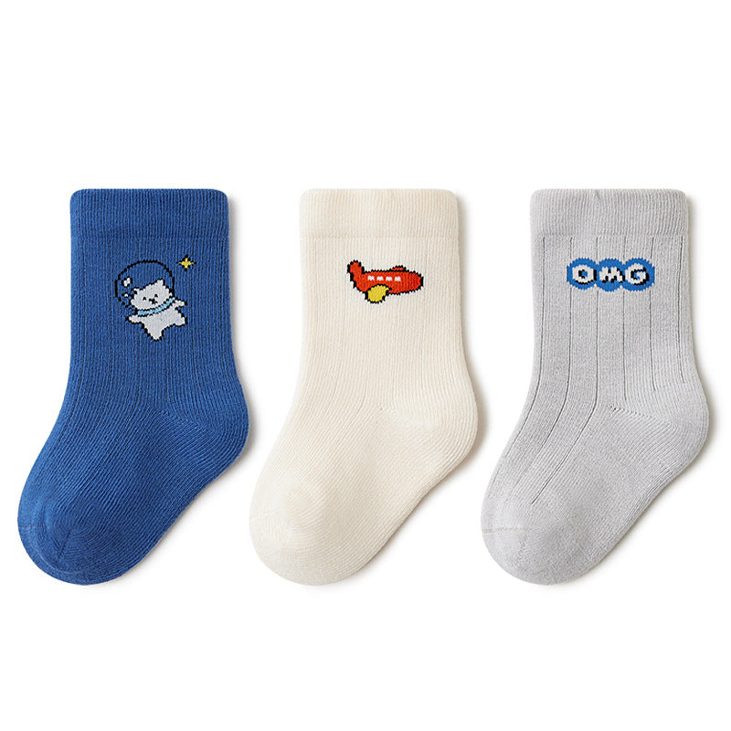 Showcasing the three pairs of socks in vibrant blue, cream, and gray, each featuring unique and playful designs like a cat in a spacesuit, an airplane, and an OMG motif.