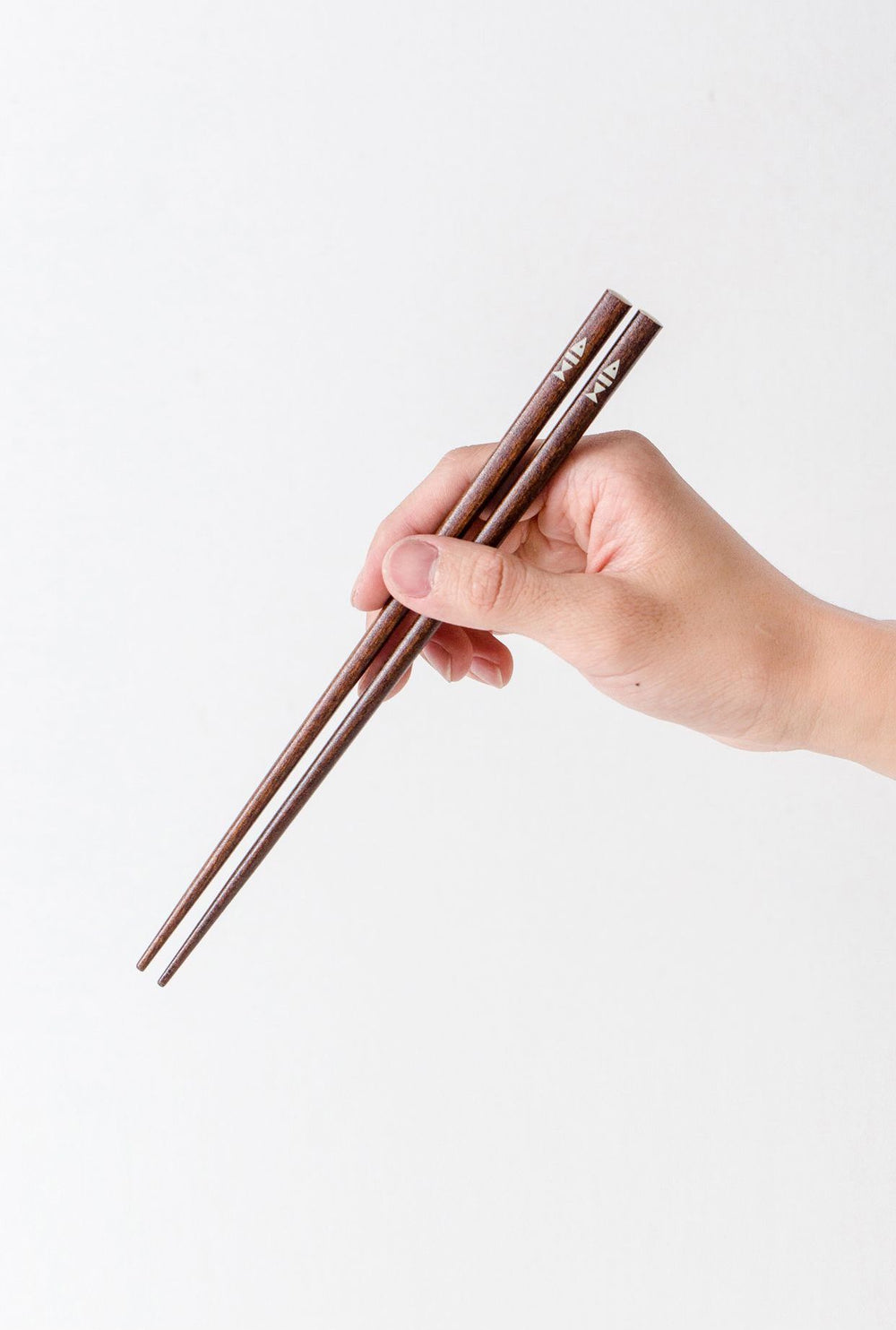 The chopsticks in use, comfortable hold in hand.