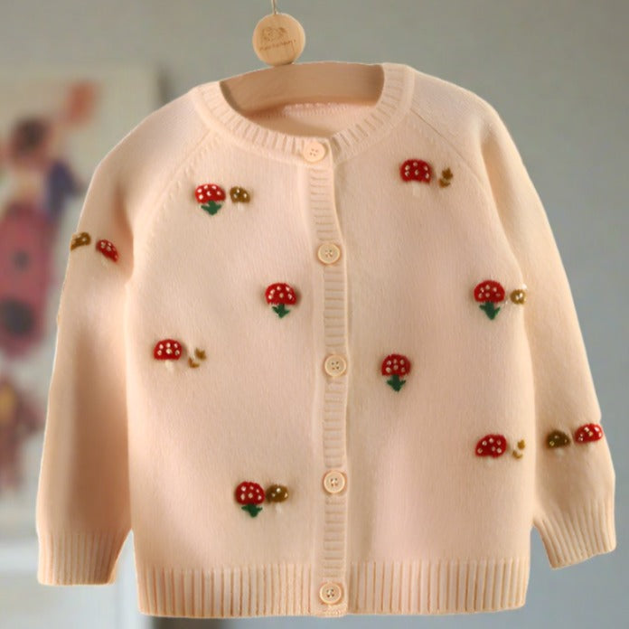 This girls' cardigan is adorned with embroidered red mushrooms on the front and sleeves.