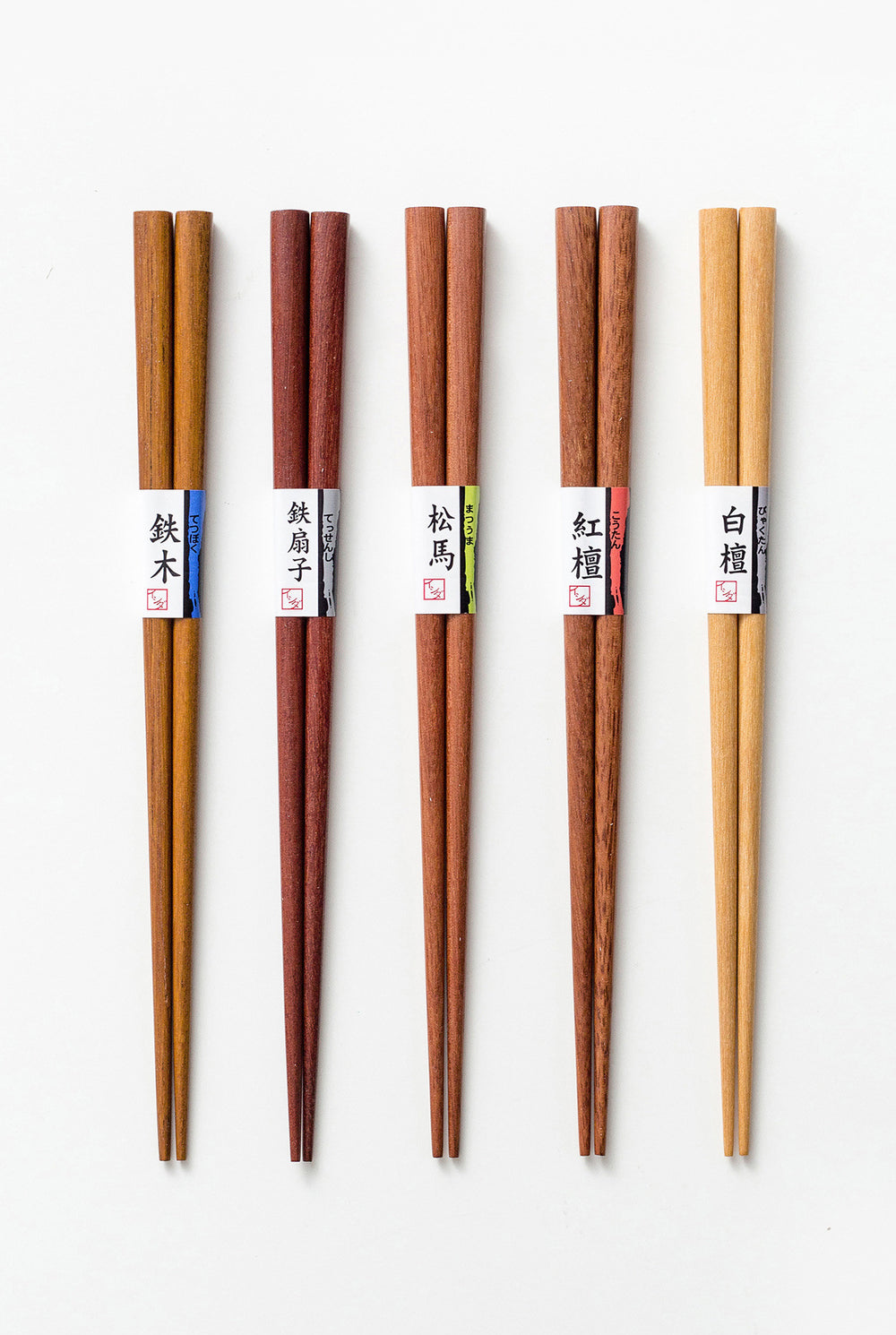 The Oriental Forest Handcrafted Japanese Chopsticks Set, showcasing all five pairs made from different types of wood, neatly arranged side by side.