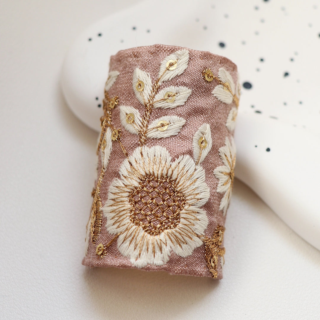 The Blushing Sakura hair wrap offers a delicate pink fabric adorned with charming white and gold sakura blossoms. This soft and feminine design brings a touch of grace and elegance to your everyday look.